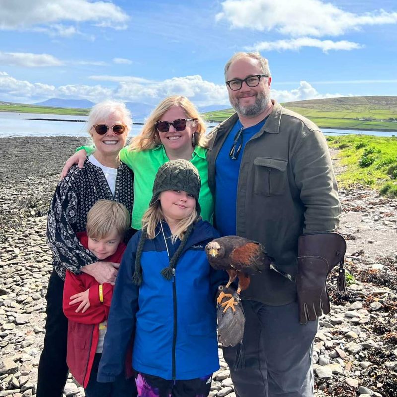 A happy family posing with a falcon on the beach