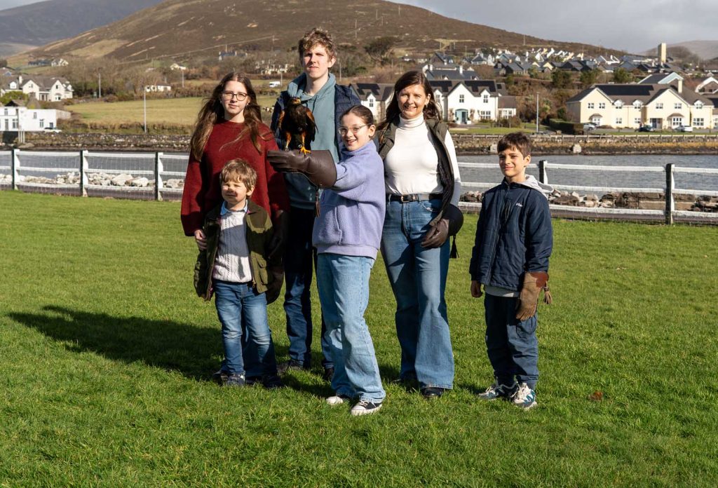 A young girl with her family posing for a photo with a falcon