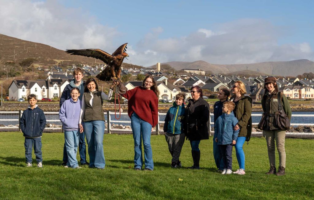 A large group posing with a hawk