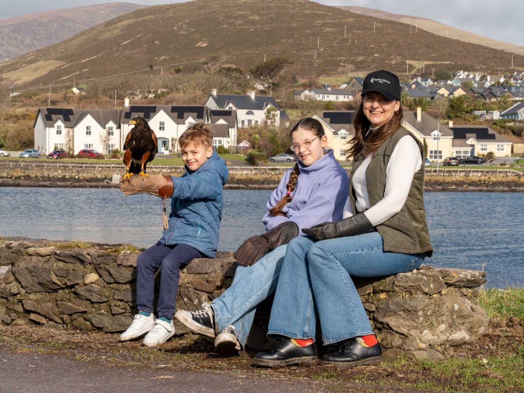 Falconry (45) A group of happy people sitting near the water with a falcon perched on their arm