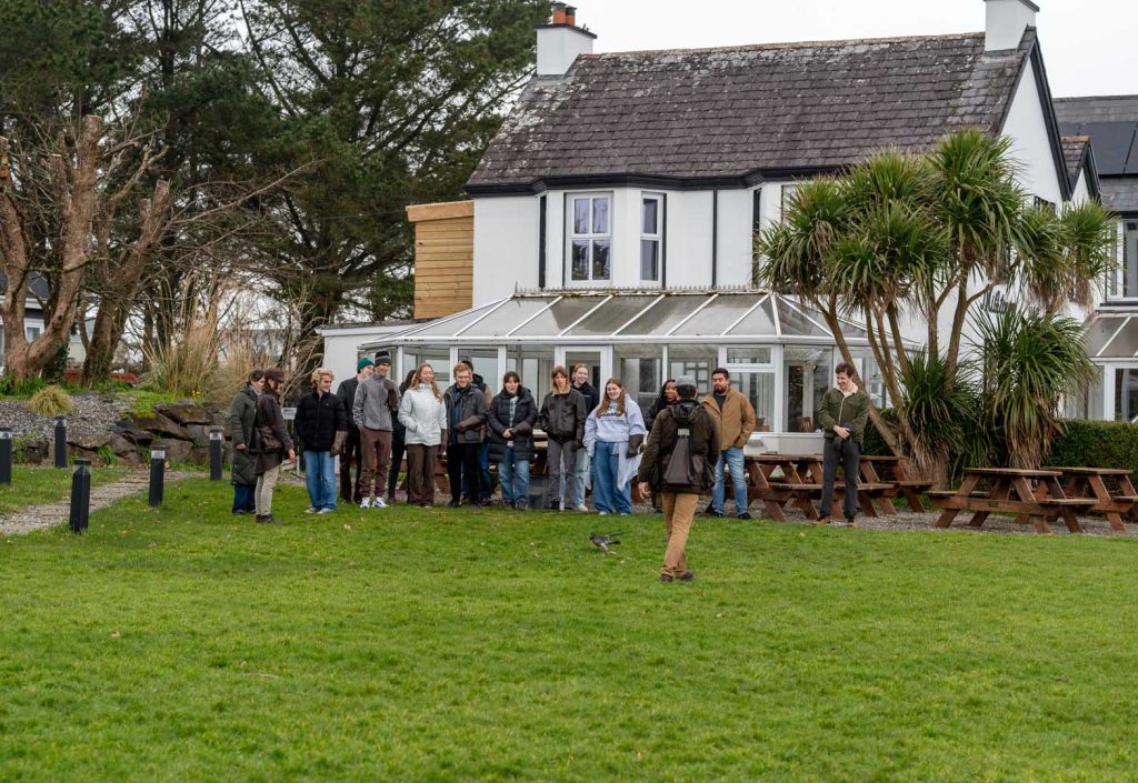 A group of visitors watching a demonstration in front of Miltown house